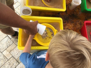 parent dumping paydirt into kids sieve